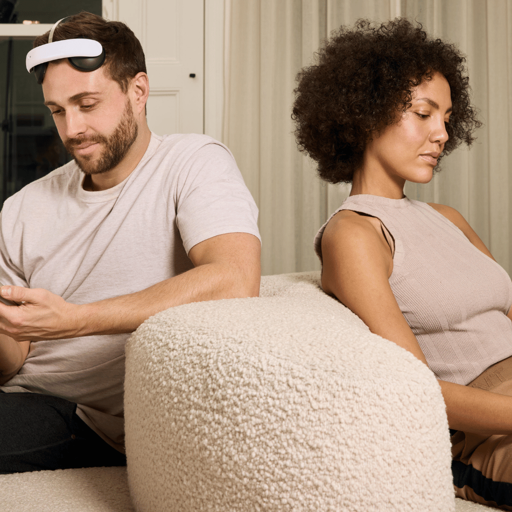 A person using the Flow headset on the sofa next to their partner