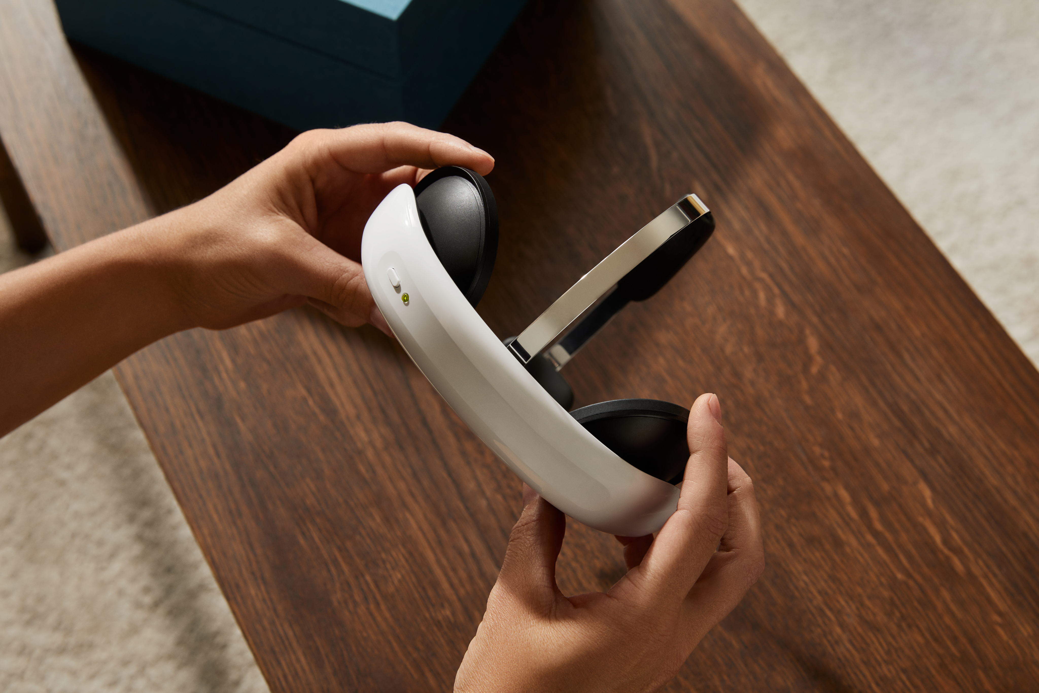 Hands holding the white Flow tDCS headset